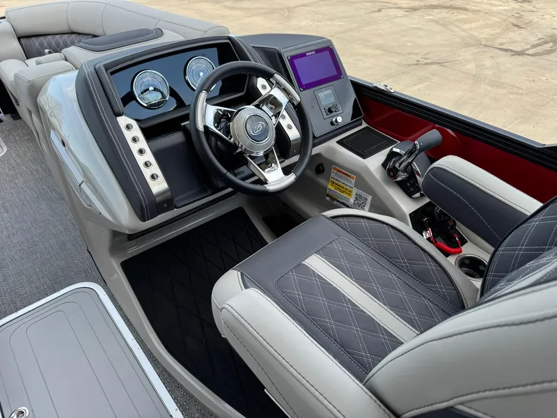 Slide: The Image of 2025 Barletta Lusso 23UC boat interior with modern dashboard and steering wheel. - 23