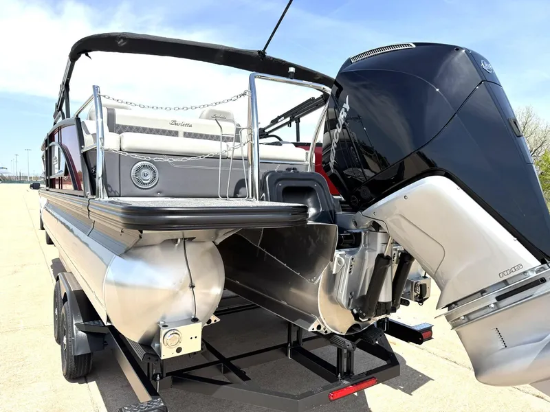 Slide: The Image of 2025 Barletta Lusso 23UC pontoon boat with powerful outboard motor, displayed on a trailer. - 7