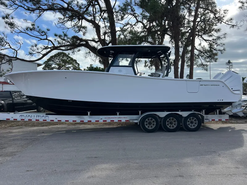 Slide: The Image of 2025 Sportsman Open 322 Center Console boat on a trailer, parked outdoors. - 2