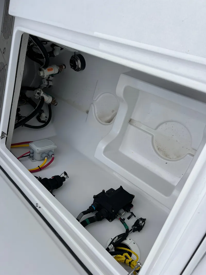 Slide: The Image of 2025 Sportsman Open 322 Center Console boat compartment with wiring and storage space. - 26