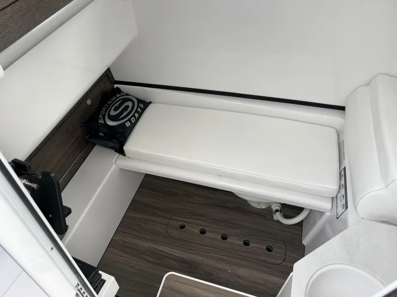 Slide: The Image of 2025 Sportsman Open 322 Center Console interior with cushioned seating and wood flooring. - 27