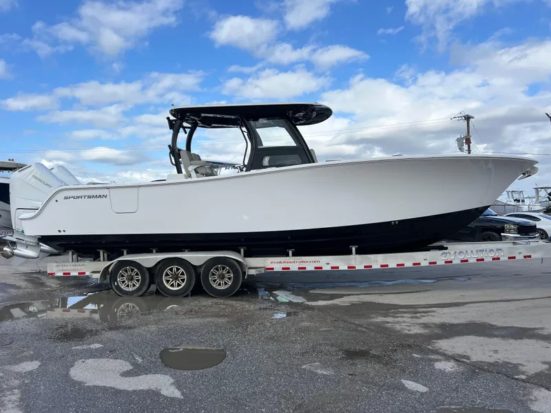 Slide: The Image of 2025 Sportsman Open 322 Center Console boat on a trailer, parked outdoors. - 6