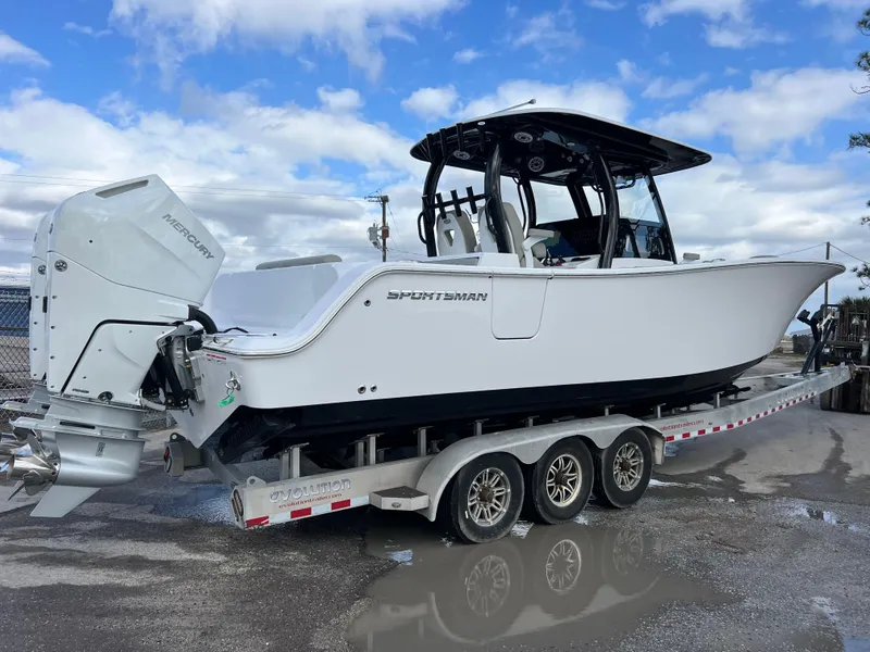 Slide: The Image of 2025 Sportsman Open 322 Center Console boat on a trailer, featuring twin Mercury engines. - 7