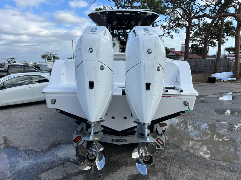 Slide: The Image of 2025 Sportsman Open 322 Center Console boat with dual outboard engines, parked outdoors. - 8