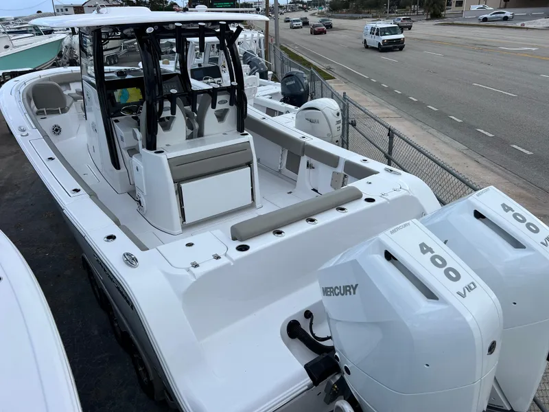 Slide: The Image of 2025 Sportsman Open 322 Center Console boat with dual Mercury 400 engines, docked near a road. - 9