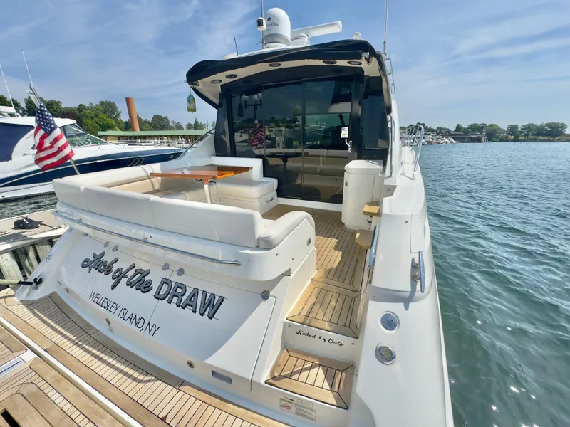 Slide: The Image of 2014 Sea Ray 510 Sundancer yacht docked, featuring spacious deck and American flag. - 12