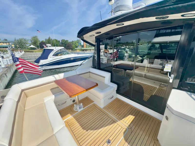 Slide: The Image of 2014 Sea Ray 510 Sundancer yacht with elegant seating and American flag at marina. - 13