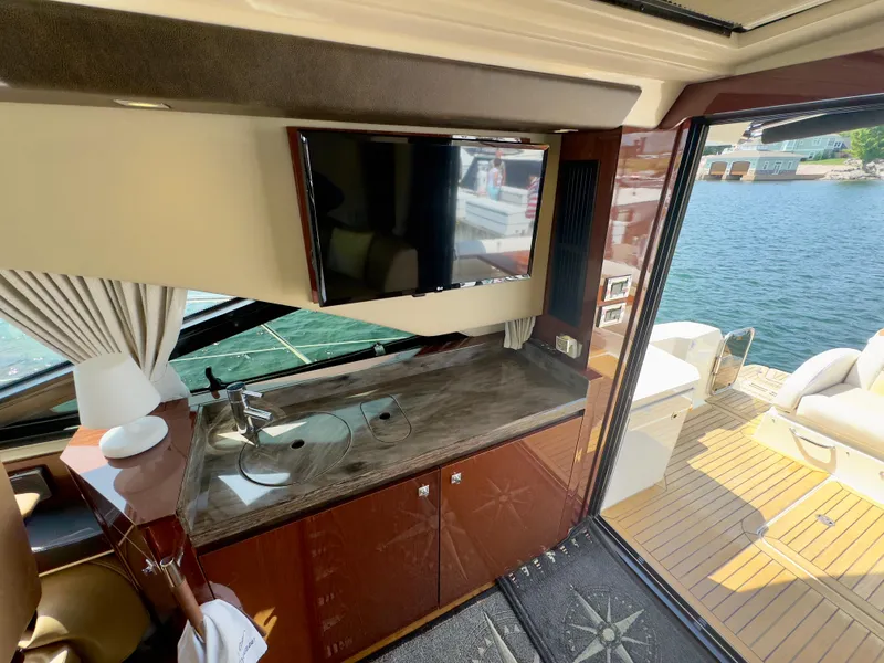 Slide: The Image of Luxurious interior of 2014 Sea Ray 510 Sundancer yacht with TV and kitchenette. - 19