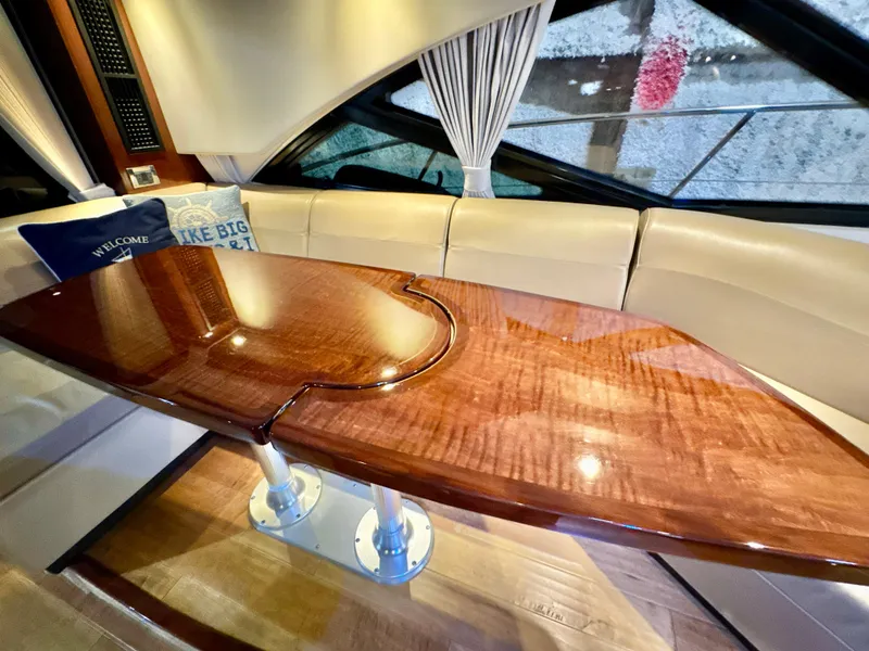 Slide: The Image of Luxurious interior of 2014 Sea Ray 510 Sundancer with polished wooden table and cream seating. - 21