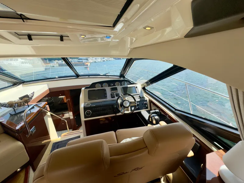 Slide: The Image of Interior view of 2014 Sea Ray 510 Sundancer yacht cockpit with steering wheel and navigation controls. - 22