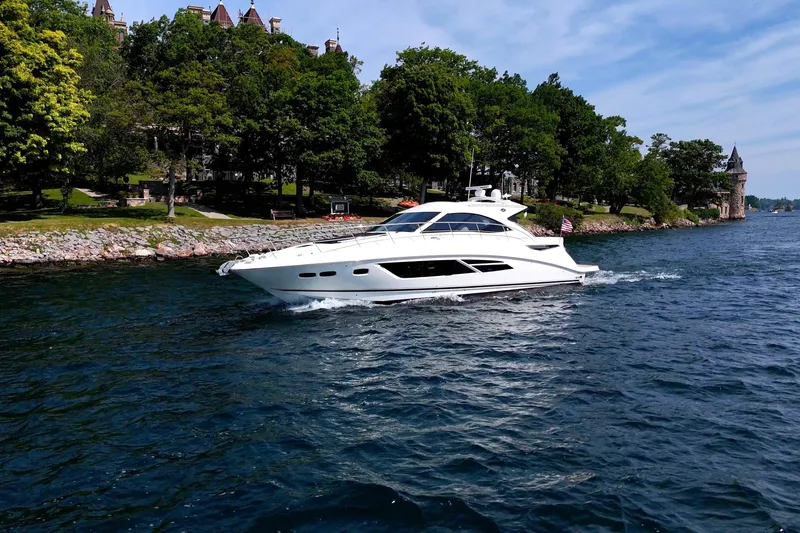 Slide: The Image of 2014 Sea Ray 510 Sundancer yacht cruising near a scenic, tree-lined shoreline. - 4