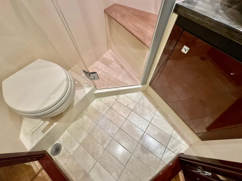 Slide: The Image of 2014 Sea Ray 510 Sundancer bathroom with shower, toilet, and wooden cabinetry. - 55