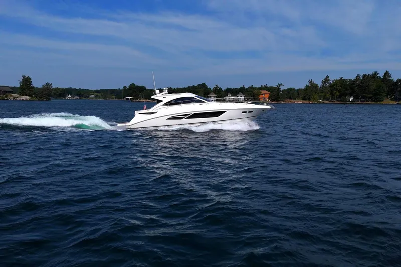 Slide: The Image of 2014 Sea Ray 510 Sundancer cruising on a scenic lake under a clear sky. - 6