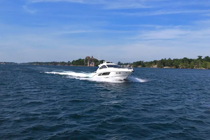 Slide: The Image of 2014 Sea Ray 510 Sundancer cruising on a scenic waterway under a clear blue sky. - 8