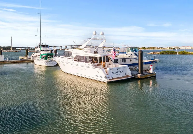 Slide: The Image of West Bay 58 Sonship yacht docked in marina, 2000 model, calm waters, clear sky. - 2
