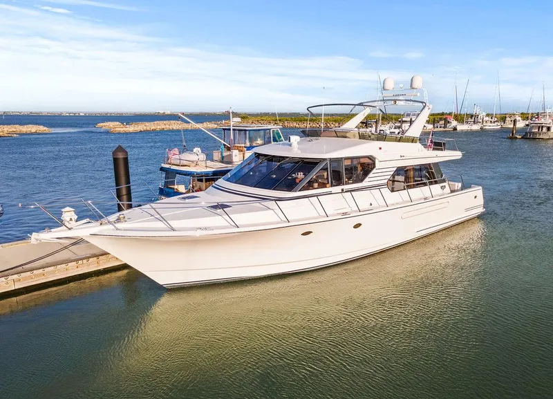 Slide: The Image of Luxury 2000 West Bay 58 Sonship yacht docked in a serene marina setting. - 3