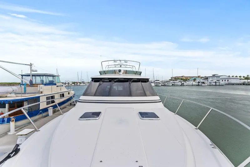 Slide: The Image of Luxury West Bay 58 Sonship yacht docked in marina, 2000 model, clear sky background. - 6
