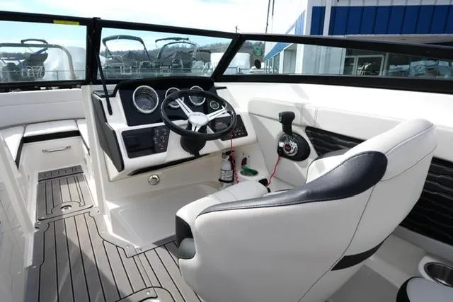 Slide: The Image of 2021 Sea Ray SPX 230 boat interior with steering wheel and dashboard controls. - 10