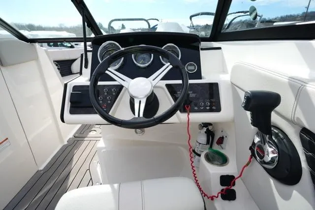 Slide: The Image of 2021 Sea Ray SPX 230 boat cockpit with steering wheel and control panel. - 11