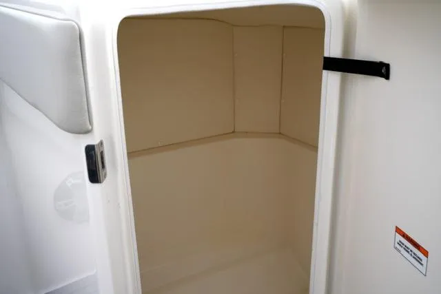 Slide: The Image of 2021 Sea Ray SPX 230 storage compartment, open door, white interior. - 13