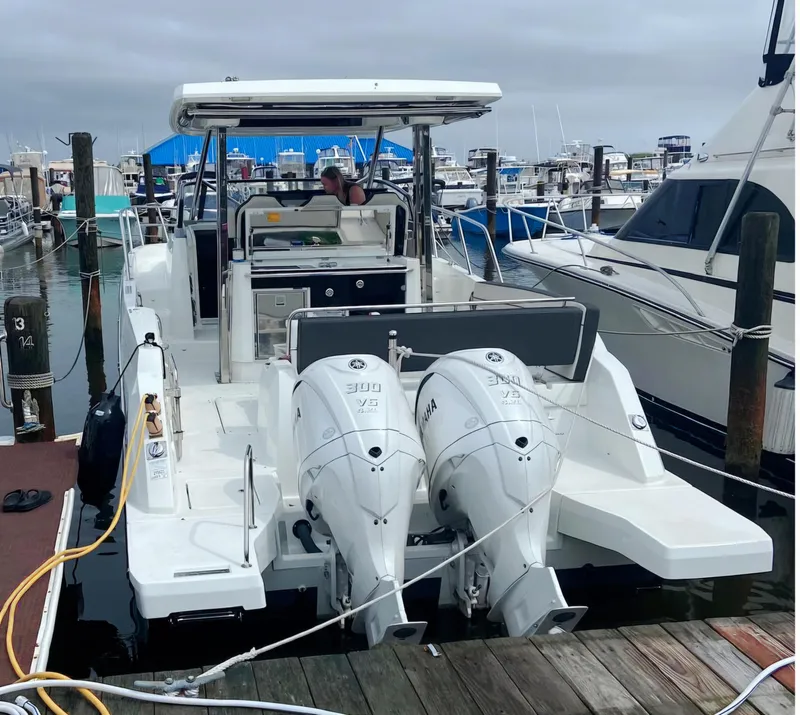 Slide: The Image of 2022 Jeanneau Leader 10.5 WA S2 boat docked with twin Yamaha engines. - 2
