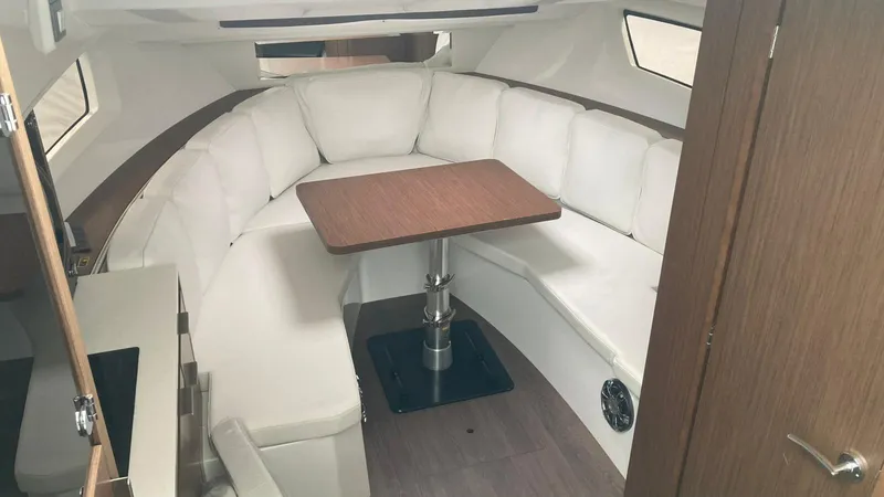 Slide: The Image of Interior of 2022 Jeanneau Leader 10.5 WA S2 with white seating and wooden table. - 4