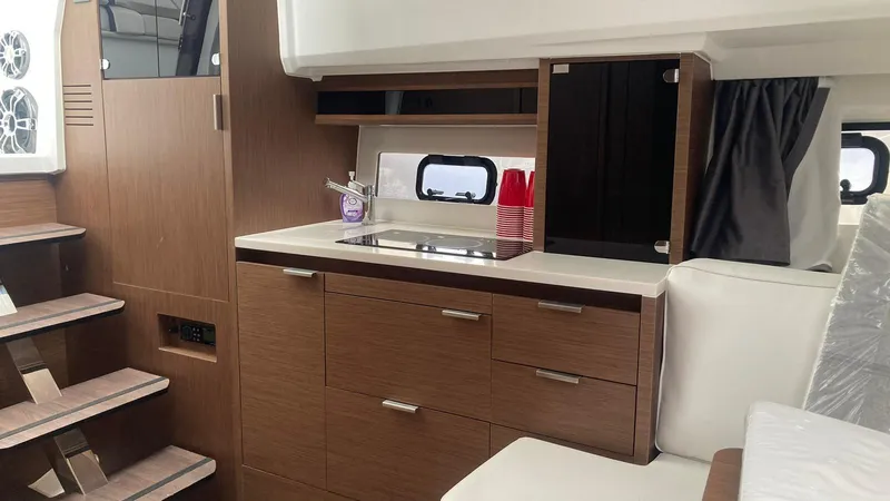 Slide: The Image of 2022 Jeanneau Leader 10.5 WA S2 interior with modern kitchenette and wooden cabinetry. - 5