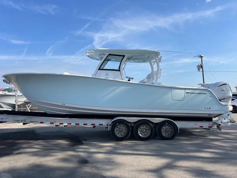 Slide: The Image of 2025 Sportsman Open 302 Center Console boat on a trailer under a clear blue sky. - 2