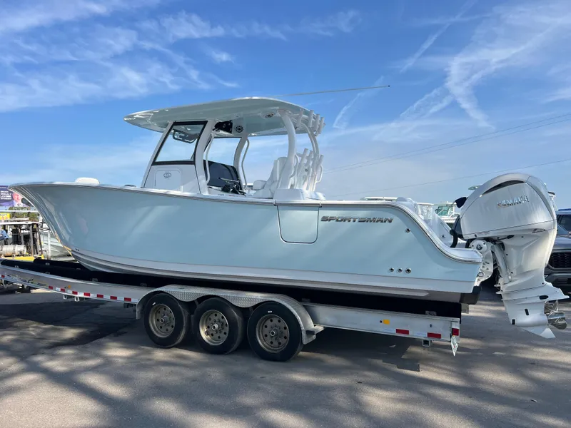 Slide: The Image of 2025 Sportsman Open 302 Center Console boat on trailer, under clear blue sky. - 3