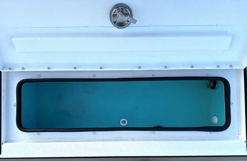 Slide: The Image of Livewell compartment of 2025 Avid Rogue 20 CC boat, featuring a secure latch. - 12