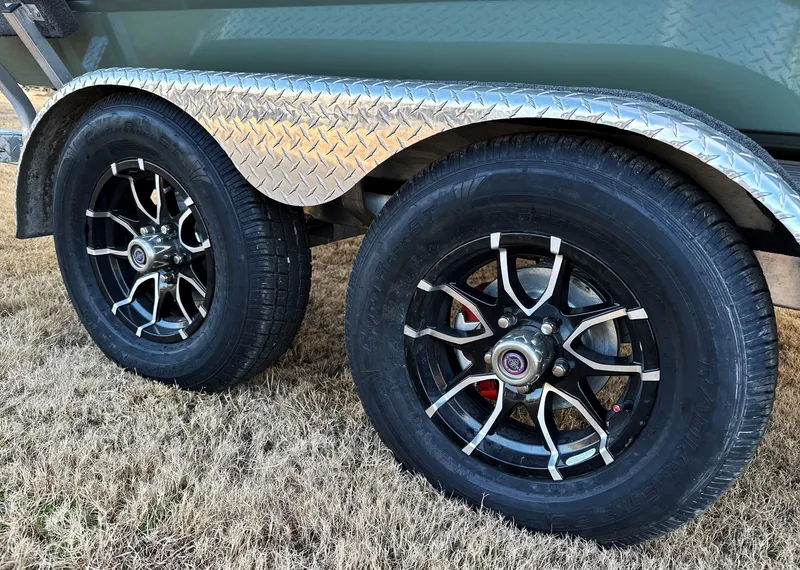 Slide: The Image of Trailer wheels of 2025 Avid Rogue 20 CC with black rims on grass. - 14