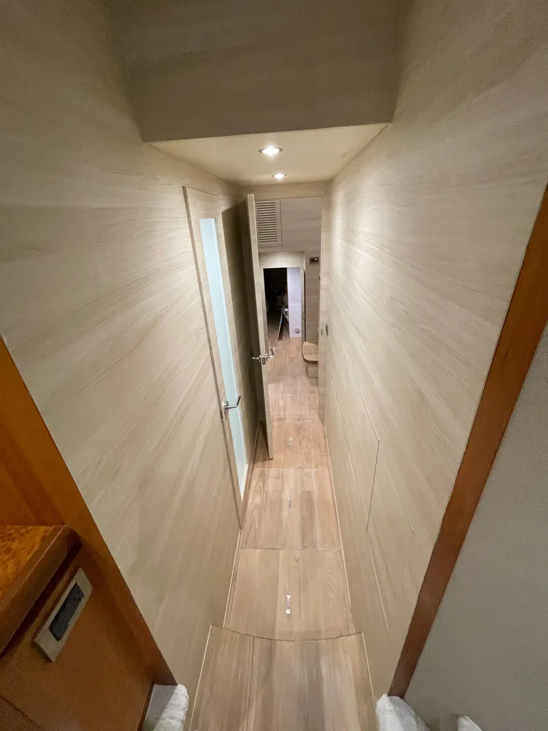 Slide: The Image of Narrow hallway inside 2017 Horizon PC60 yacht, featuring wooden flooring and modern lighting. - 11