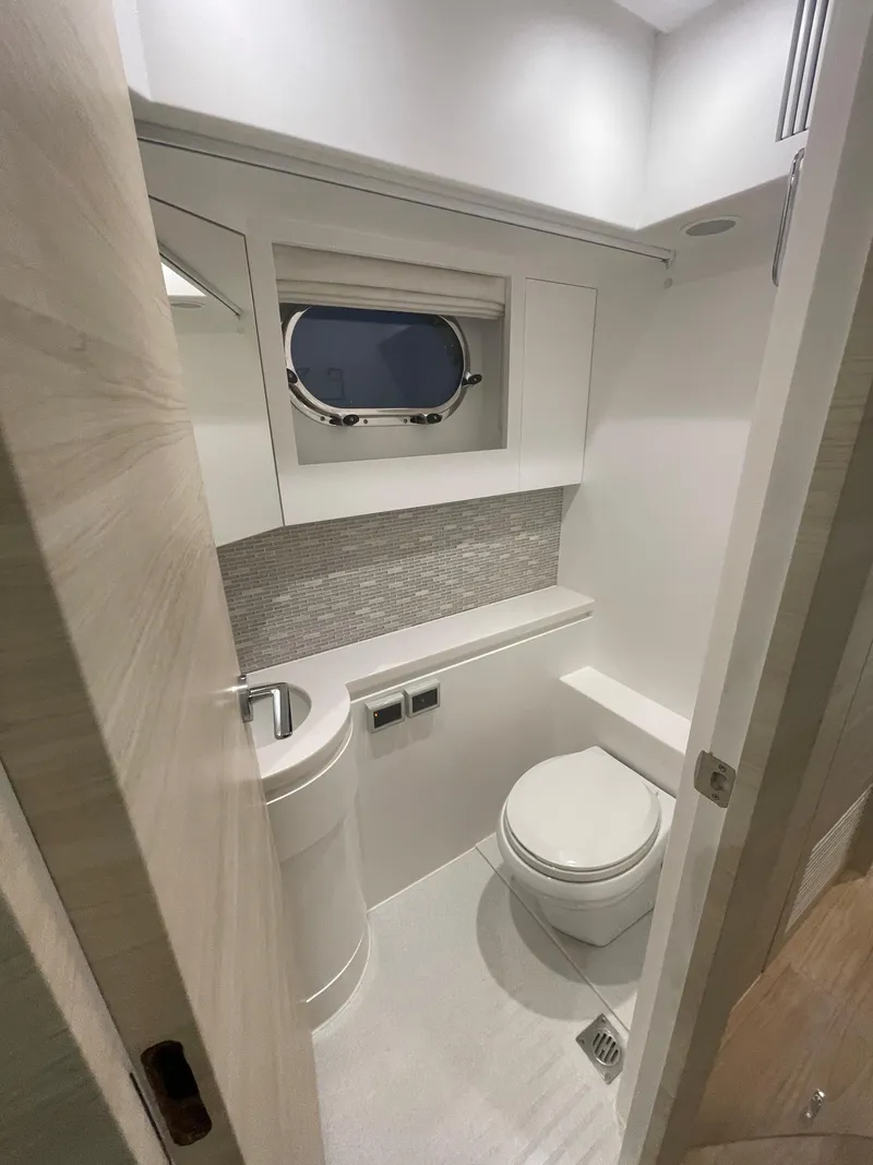 Slide: The Image of Modern yacht bathroom with sleek design, featuring a round sink and porthole window. Horizon PC60, 2017. - 15