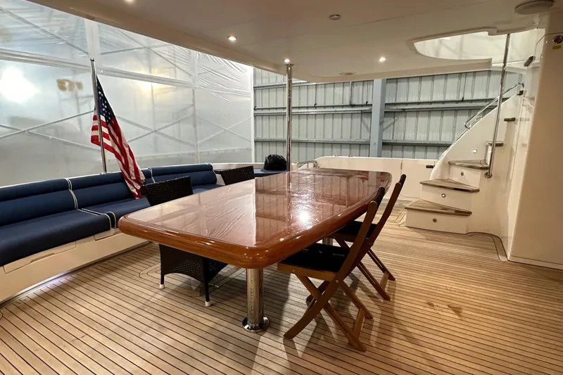 Slide: The Image of Luxurious Horizon PC60 yacht deck with wooden table, chairs, and American flag, 2017 model. - 20