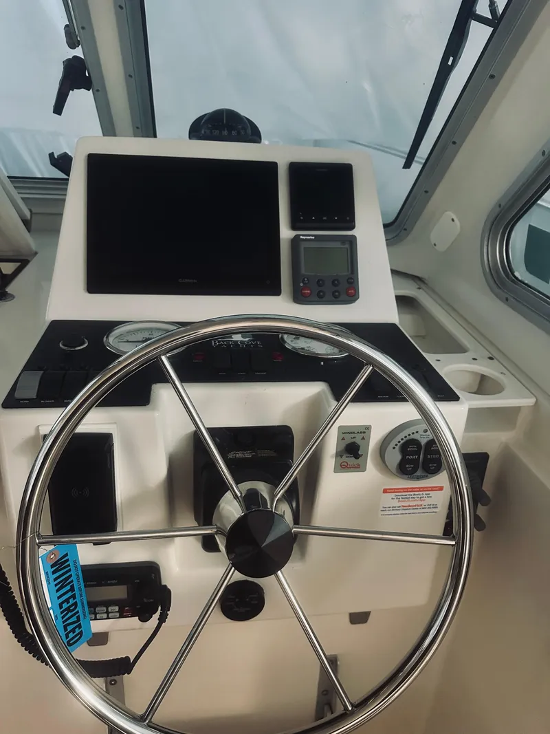 Slide: The Image of Helm of 2006 Back Cove 29 boat with steering wheel and navigation instruments. - 18