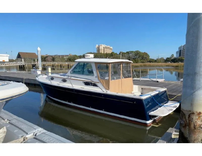 Slide: The Image of 2006 Back Cove 29 boat docked in a marina under clear blue skies. - 2