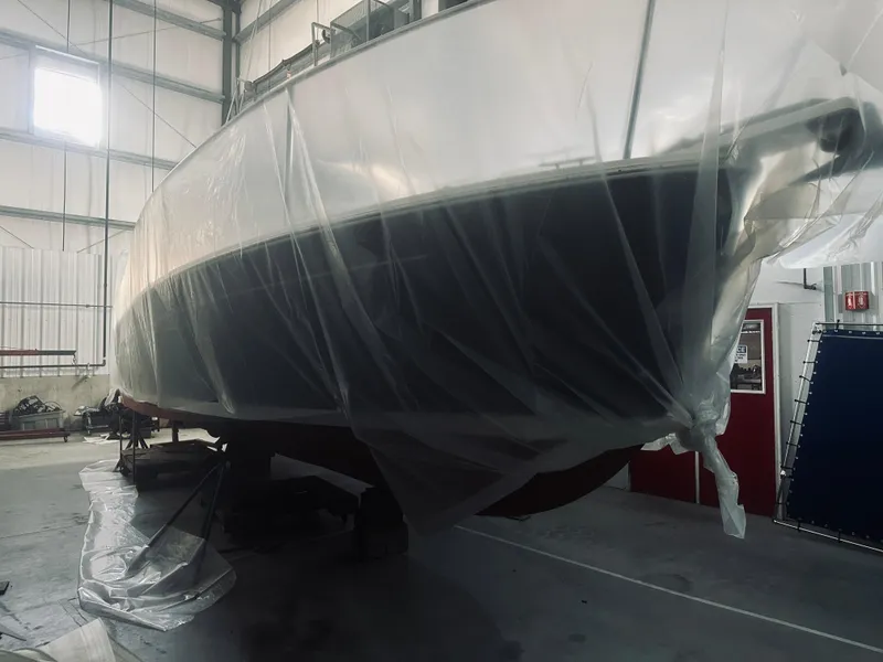 Slide: The Image of 2006 Back Cove 29 boat covered in protective plastic in a storage facility. - 29