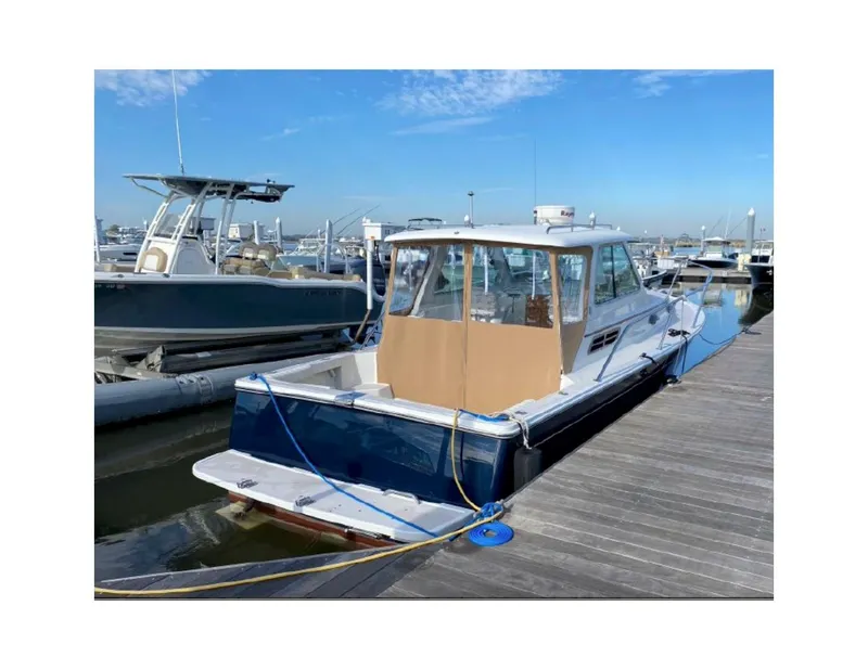 Slide: The Image of 2006 Back Cove 29 boat docked at marina under clear blue sky. - 4