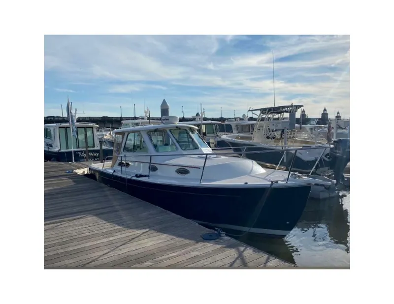 Slide: The Image of 2006 Back Cove 29 boat docked at marina under clear sky. - 5
