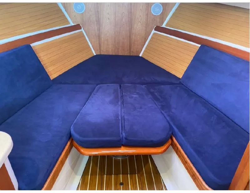 Slide: The Image of 2006 Back Cove 29 interior with blue cushioned seating and wooden accents. - 7