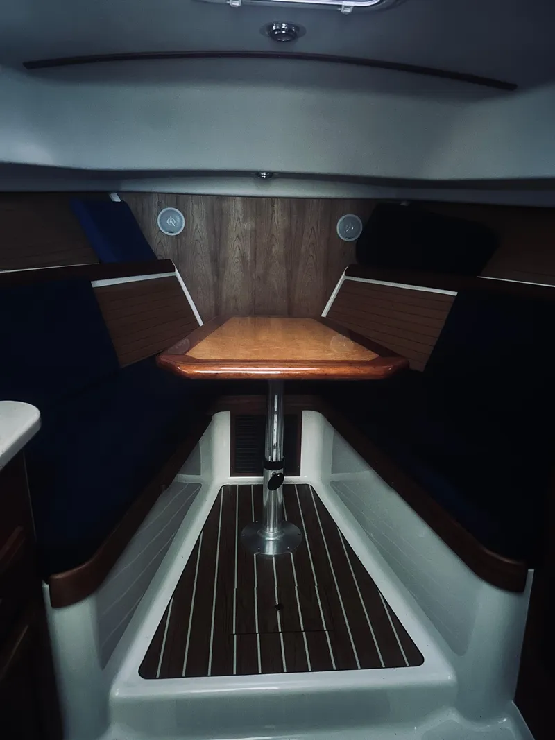 Slide: The Image of 2006 Back Cove 29 interior cabin with wooden table and seating. - 8