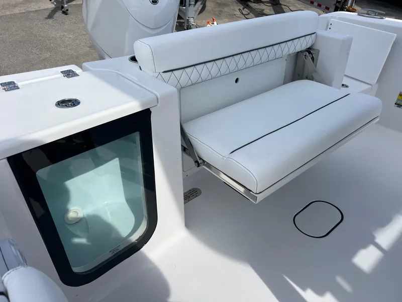 Slide: The Image of 2025 Sportsman Open 212 Center Console boat interior with white seating and storage compartment. - 19