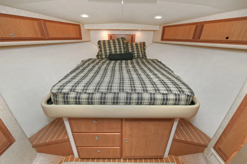 Slide: The Image of Luxurious cabin interior of 2007 Cabo 40 Express yacht, featuring a cozy bed and wooden cabinetry. - 18