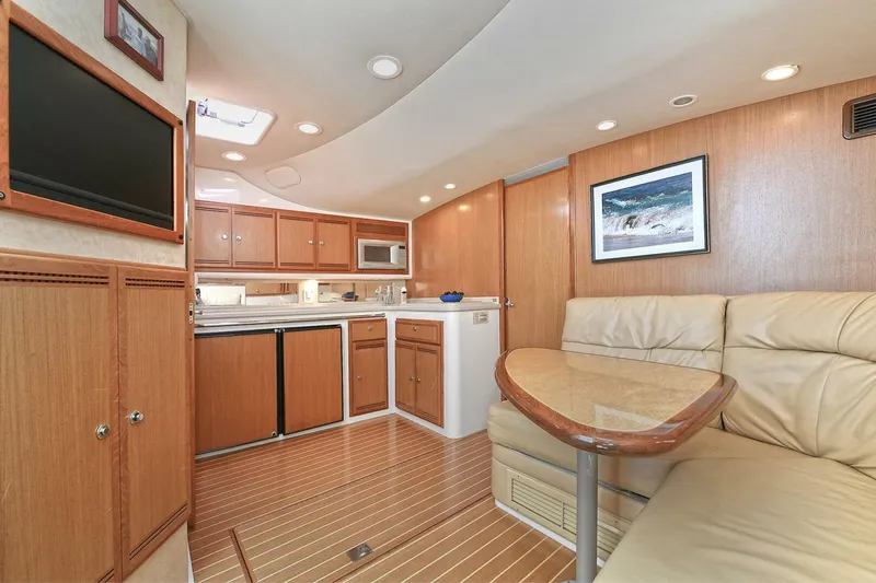 Slide: The Image of 2007 Cabo 40 Express yacht kitchen with wooden cabinets, microwave, and countertop sink. - 21