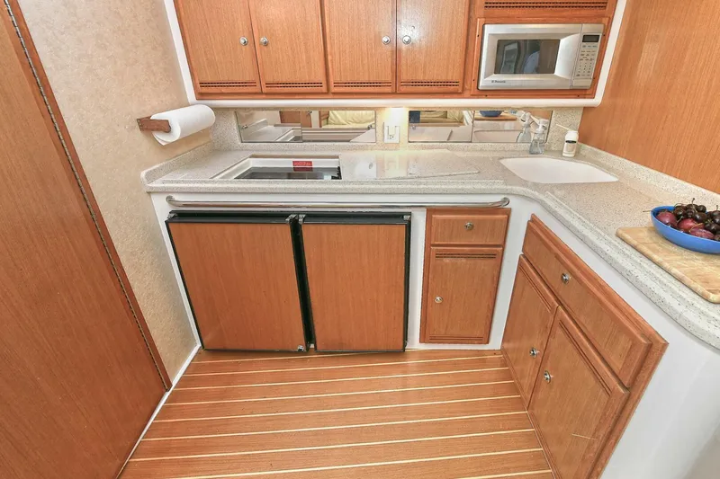 Slide: The Image of 2007 Cabo 40 Express kitchen with stove, wooden cabinets, and countertop. - 22