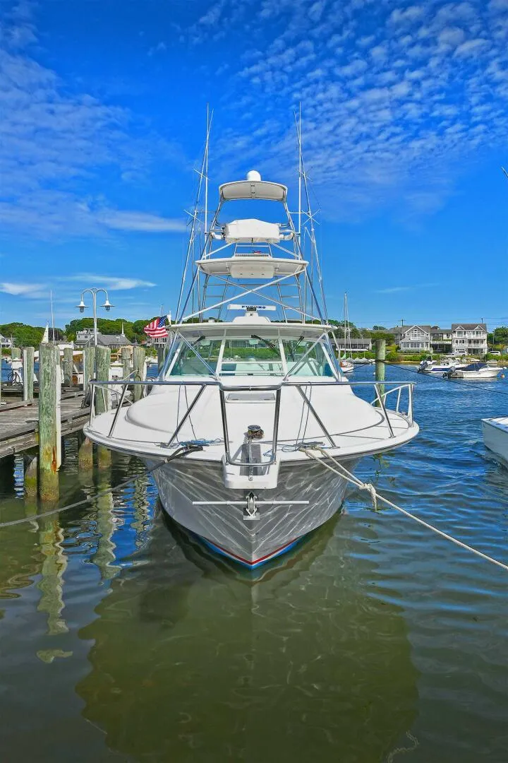 Slide: The Image of 2007 Cabo 40 Express with Tower docked, showcasing sleek design and spacious deck under clear blue sky. - 3