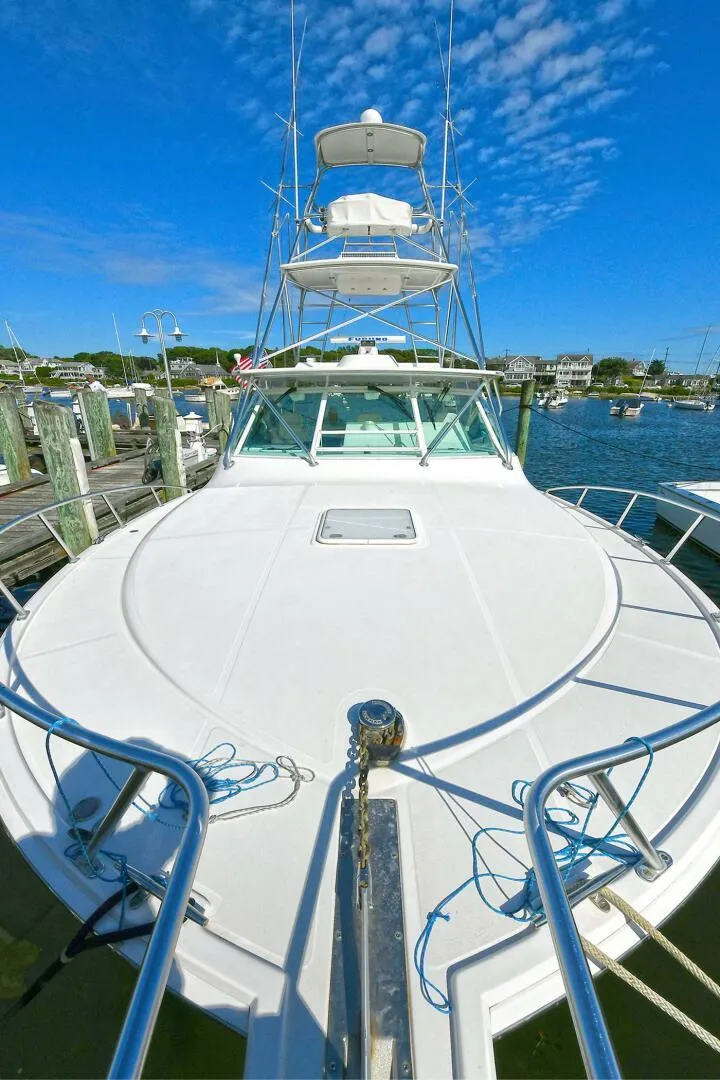 Slide: The Image of 2007 Cabo 40 Express boat deck with fishing rod holders, near wooden dock. - 4