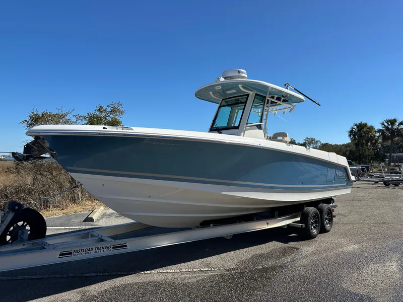 Slide: The Image of 2023 Boston Whaler 280 Outrage boat on trailer under clear blue sky. - 11