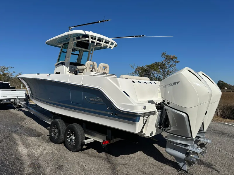 Slide: The Image of 2023 Boston Whaler 280 Outrage boat on trailer, featuring dual Mercury engines. - 12
