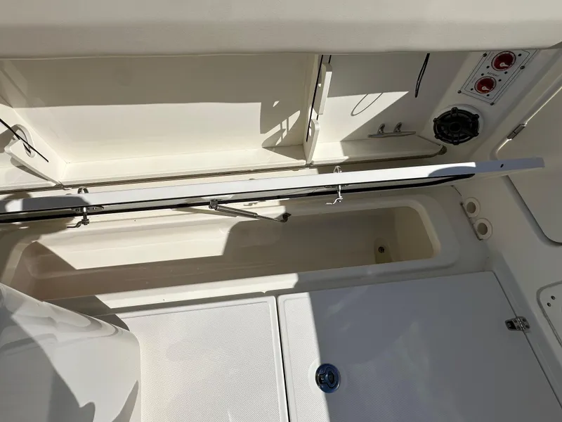 Slide: The Image of 2023 Boston Whaler 280 Outrage storage compartment with open hatch and visible interior features. - 40